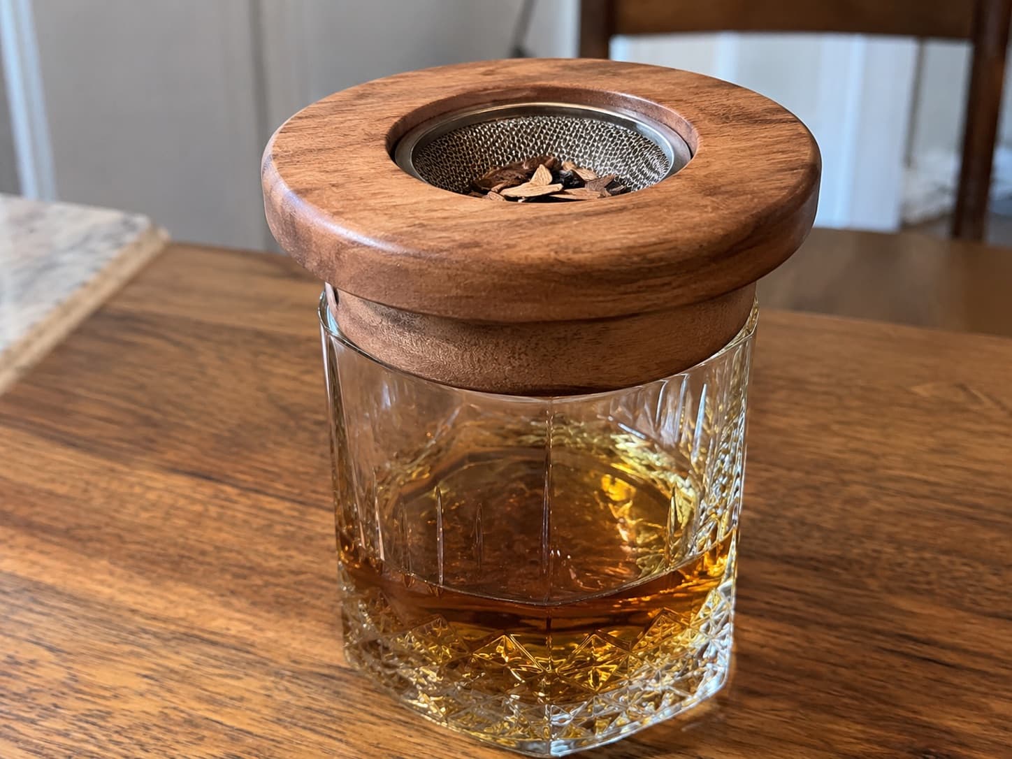 Wooden smoke lid on a tumbler, with wood chips in the mesh chamber